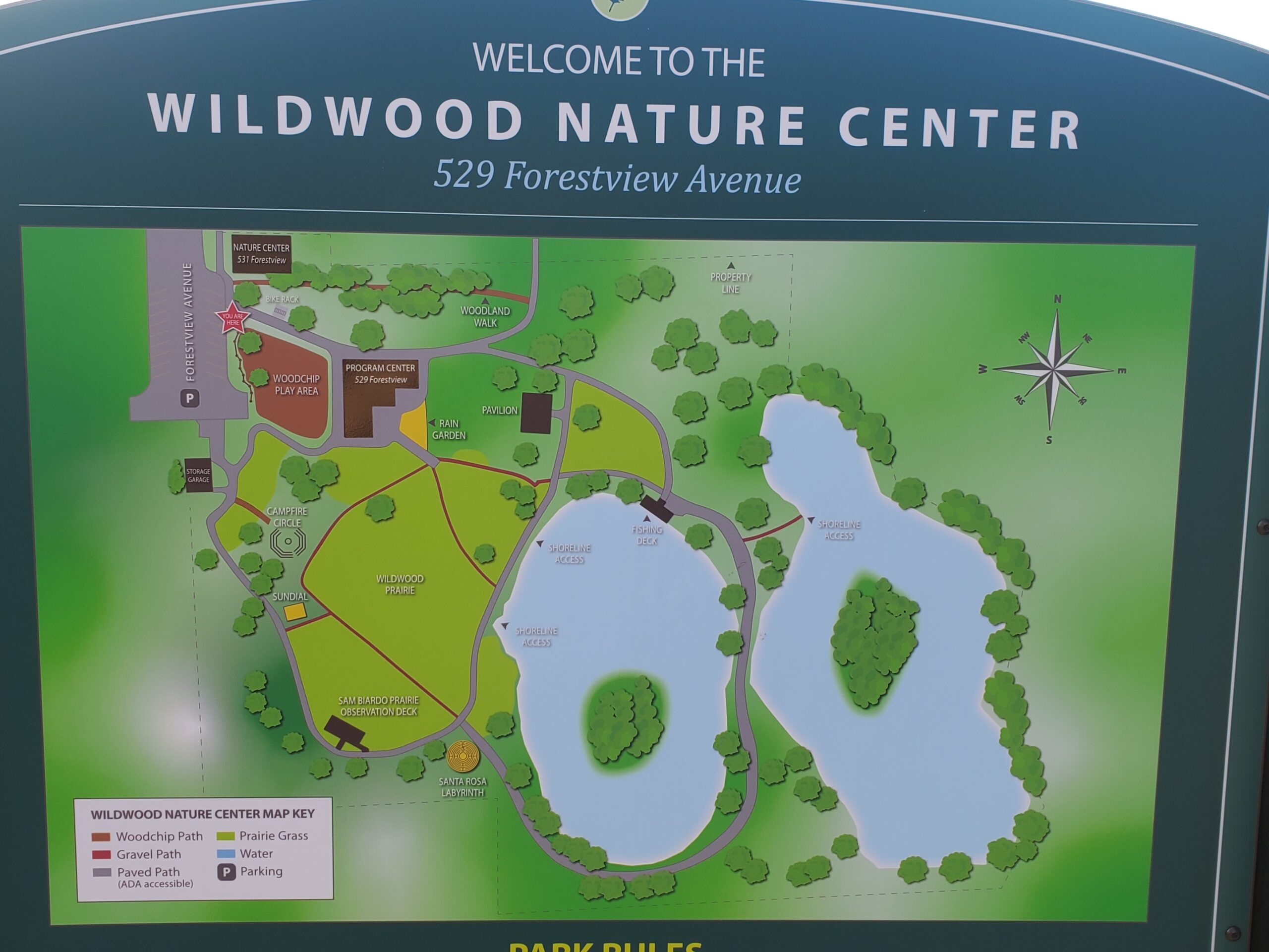 A sign with a detailed map of the Wildwood nature Center campus that includes the map key